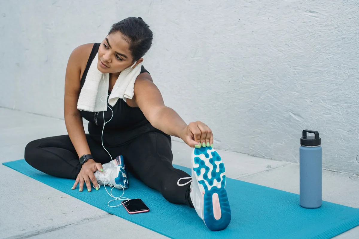 A woman stretching on a yoga mat outdoors