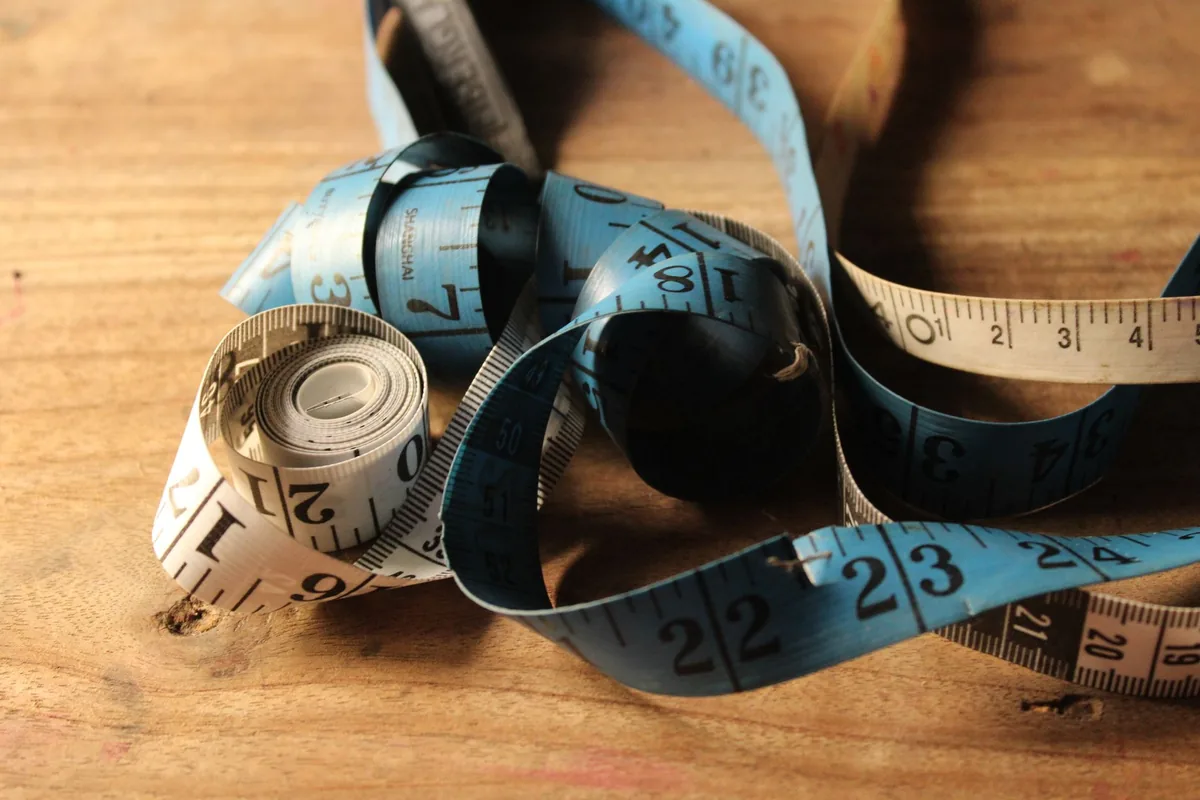 A rolled tape measure on a wooden surface