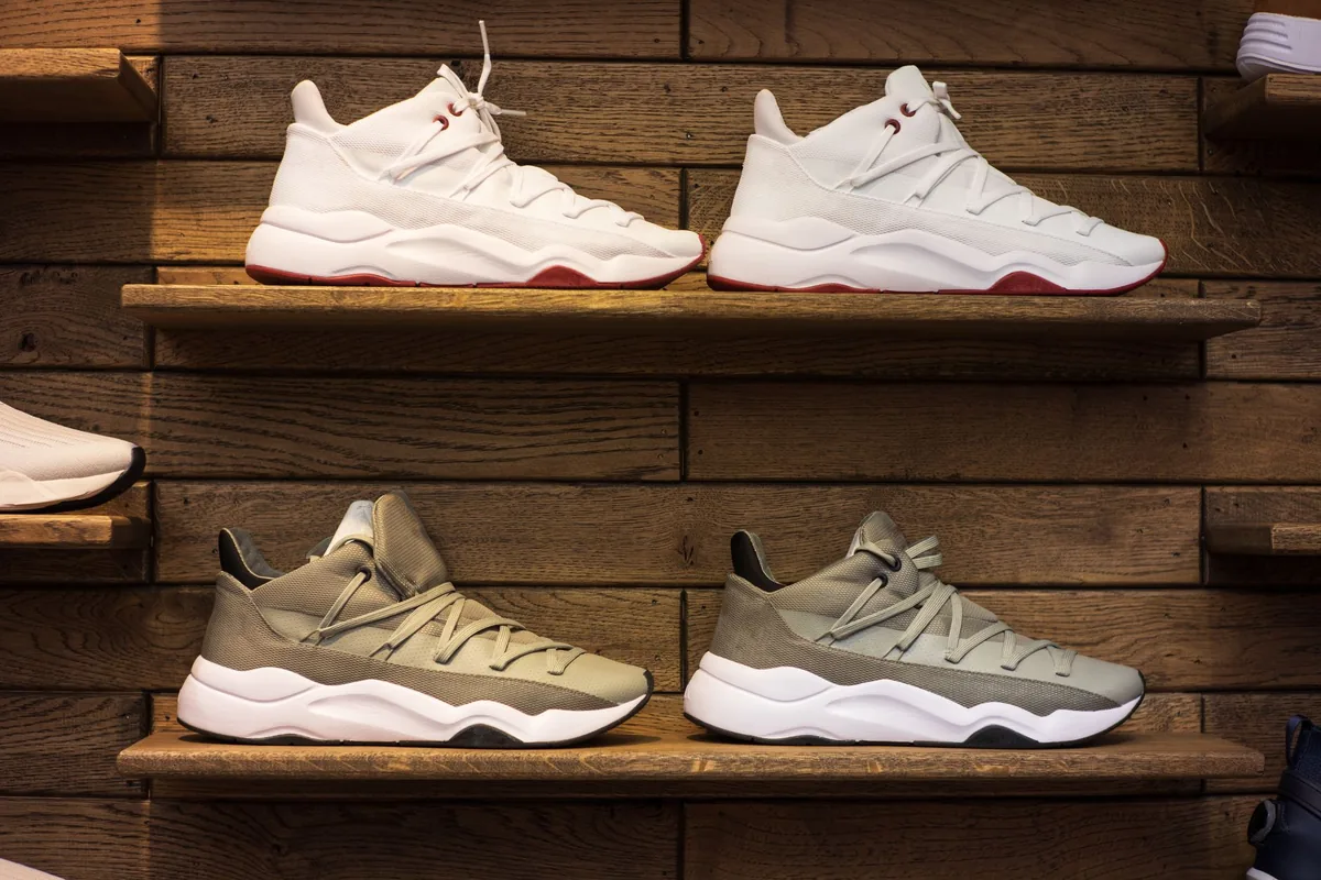 White and grey sneakers displayed on wooden shelves