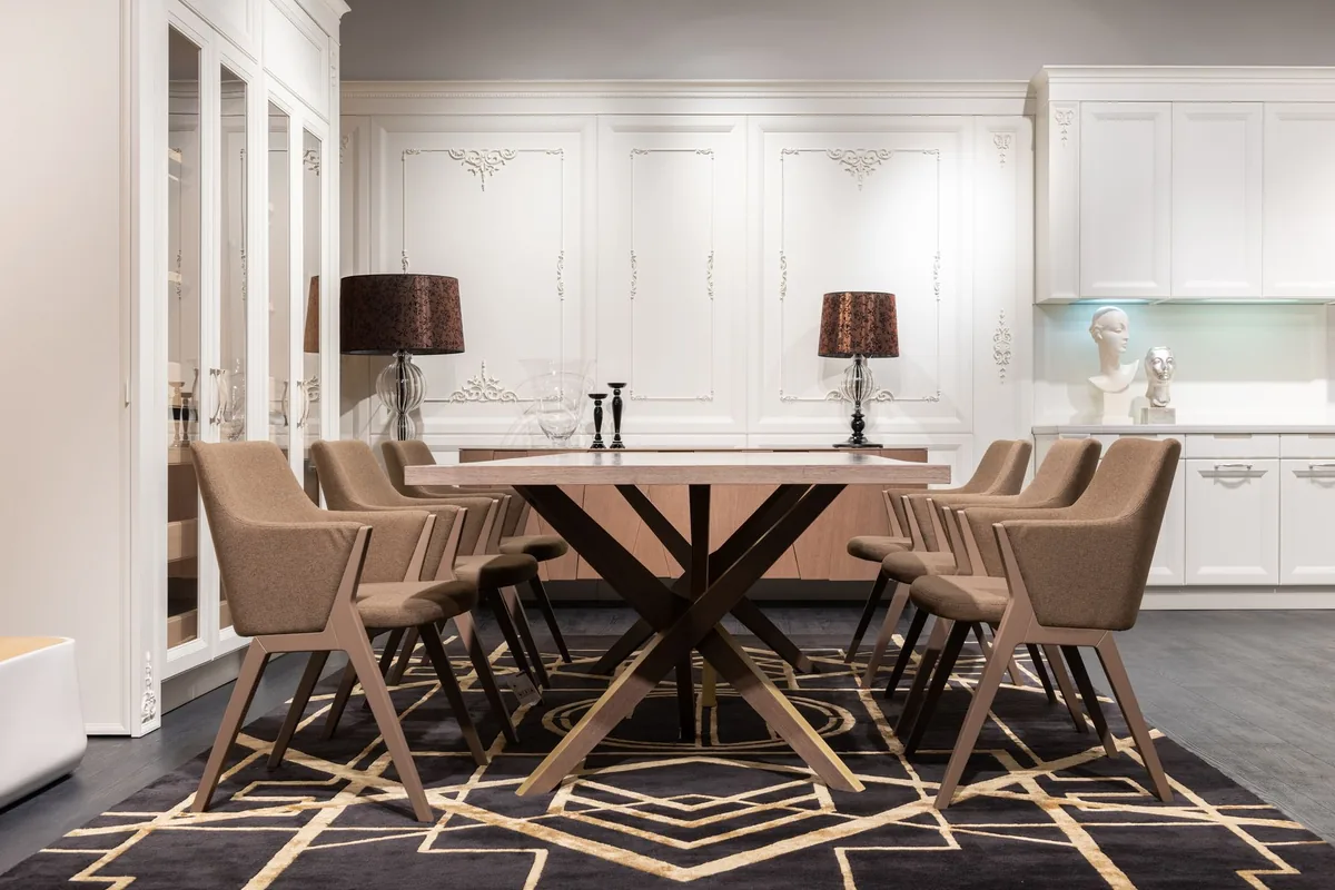 Brown upholstered dining armchairs with angled wooden frames around a long table on a patterned rug