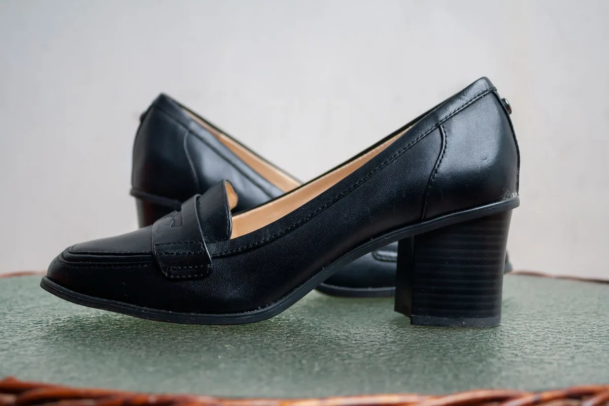 A pair of black leather shoes with low block heels